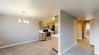This single-floor residence offers a practical and comfortable layout across two bedrooms, one bathroom, and dedicated laundry space. The combined kitchen and living area serves as the heart of the home, featuring light wood cabinetry, white countertops, and stainless steel appliances including an electric range. Light wood-style flooring runs through the kitchen and dining area, while a chandelier overhead adds a touch of warmth. A window in the dining space allows natural light to filter in with views of the surrounding neighborhood.

Both bedrooms are carpeted and finished in neutral warm-toned paint, providing a calm and restful atmosphere. The primary bedroom offers a comfortable footprint, while the second bedroom also features a window with outdoor views. Both rooms include built-in heating units for year-round comfort.

The bathroom is cleanly appointed with wood-toned cabinetry, a single-sink vanity, a full shower/tub combination, and light wood-style flooring that complements the rest of the home. The dedicated laundry area includes a full-size washer and dryer with overhead shelving for added storage. Throughout, white trim and neutral wall tones create a cohesive, move-in-ready aesthetic.