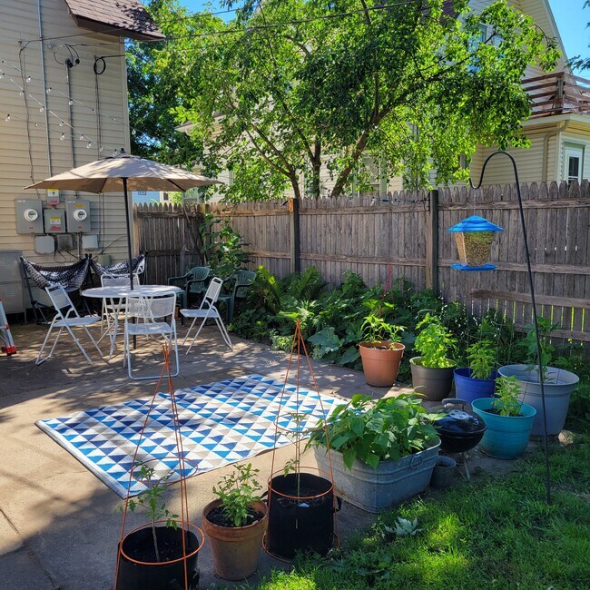 Patio trasero con cerca de privacidad y un patio de cemento. - 783 Edmund Ave W