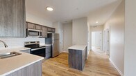 Located at Hurstbourne Pointe in Louisville, KY, this two-bedroom, two-bathroom residence offers a thoughtfully designed single-floor layout with a cohesive, modern aesthetic throughout. Light-toned hardwood-style flooring runs continuously across the space, creating a warm and unified feel.

The kitchen is a standout feature, showcasing dark wood cabinetry with brushed hardware, light quartz countertops, a classic white subway tile backsplash, and a full suite of stainless steel appliances including a range, microwave, refrigerator, and dishwasher. A central island provides additional prep and serving space, while the open sightline connects seamlessly to the rest of the unit.

The primary bedroom is a comfortable size, filled with natural light from a window with blinds, and includes a ceiling fan and a spacious closet with built-in shelving. The second bedroom mirrors this layout with similar finishes and natural light. Both bathrooms are finished with dark wood vanities, light countertops, and hardwood-style flooring; one features a tub-shower combination. A dedicated laundry room with washer and dryer hookups adds everyday convenience. Two closets provide ample storage throughout the residence.