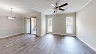 Located at 6925 Roswell Rd in Sandy Springs, GA, this two-story home offers a practical and well-organized layout split evenly between two floors. The main level features a spacious living room with warm wood-look flooring, crown molding, a textured ceiling, and a ceiling fan, creating a bright and comfortable gathering space. Natural light flows in through windows fitted with blinds, and a pendant light fixture adds a finishing touch. The kitchen is equipped with stainless steel appliances, including a full-size refrigerator and range, complemented by dark wood cabinetry, granite-style countertops, and matching wood-look flooring that continues from the main living areas. A hallway connects the main level to the staircase leading upstairs. The upper floor houses both bedrooms, each featuring plush carpeting, textured ceilings, ceiling fans, and windows with outdoor views. The generously sized primary bedroom includes direct access to its own bathroom, complete with a dark wood vanity, white countertop, and a tub-shower combination. Two additional bathrooms serve the home, both featuring consistent dark-toned cabinetry and mirrored vanities. Three closets throughout the home provide ample storage, including a walk-in closet with built-in shelving and hanging rods. Neutral gray tones throughout create a cohesive and move-in-ready aesthetic.