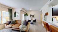 This 2-bedroom, 1-bathroom residence in Independence, Missouri offers a practical and well-designed single-floor layout. The open living and dining area is bathed in natural light through large windows dressed with elegant green curtains, with plush carpet flooring adding warmth throughout. The living space flows naturally into a designated dining area, creating a cohesive and inviting atmosphere.

The kitchen is a standout feature, showcasing rich dark-wood cabinetry, light marble-style countertops, classic white subway tile backsplash, and stainless steel appliances including a refrigerator, range, and microwave. Light wood-style tile flooring ties the space together cleanly.

The primary bedroom is generously proportioned, featuring a ceiling fan, a walk-in closet with built-in wire shelving, and a window that allows in natural light. The second bedroom also includes a ceiling fan and carpeted flooring. Both rooms offer a calm, restful ambiance.

The bathroom is clean and functional, featuring a tiled tub-shower combination, a dark wood vanity with a marble-style countertop, and wood-look tile flooring. A bright hallway connects all rooms efficiently, with additional storage and utility access nearby. Overall, the residence delivers a cohesive, modern aesthetic with practical amenities throughout.