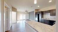 Located on S Tyler Ave in Loveland, Colorado, this single-story, 1-bedroom, 2-bathroom residence offers a thoughtfully designed open-concept layout. Wood-style flooring flows throughout the main living areas, connecting the kitchen, dining, and living spaces seamlessly. The kitchen is a standout feature, equipped with rich dark cabinetry, light granite-style countertops, a subway tile backsplash, black appliances including a refrigerator, range, microwave, and dishwasher, and a peninsula island that provides additional prep space and casual seating. A ceiling fan with light fixture anchors the living area, which is brightened by natural light from a set of glass-paneled doors leading to the exterior. A hallway connects the main living space to the private bedroom, which is carpeted and features its own ceiling fan, natural light from a large window, and access to a closet. Both bathrooms are finished with the same dark cabinetry and light countertops consistent with the rest of the home, with wood-style flooring for easy maintenance. Clean neutral tones throughout lend a fresh, modern ambiance to the entire space, making it a comfortable and functional home in Loveland's residential corridor.