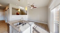 Located at 9275 Lyndon B Johnson Fwy in Dallas, TX, this single-floor, one-bedroom, one-bathroom residence offers a thoughtfully designed layout that maximizes every square foot. The open-concept living area seamlessly combines the kitchen, dining, and living spaces into one bright, airy zone. Large sliding glass doors invite abundant natural light and provide access to a balcony, enhancing the sense of openness.

The kitchen is a standout feature, equipped with stainless steel appliances including a range, microwave, and refrigerator. White shaker-style cabinetry extends to the ceiling for ample storage, while granite countertops and a center island with a double stainless steel sink add both style and functionality. Pendant lighting above the island and a ceiling fan over the living area complete the space.

Wood-look flooring runs throughout, lending warmth and continuity. A dedicated hallway connects the living areas to the private bedroom, bathroom, and additional spaces including a pantry, laundry area, and two closets. The bathroom features granite countertops, cabinetry, and a tiled shower. The entrance provides a welcoming transition into the home. Overall, the unit presents a clean, modern aesthetic with practical storage and well-appointed finishes.