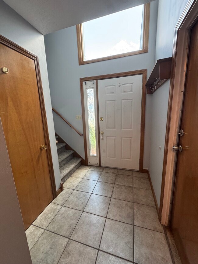 Entrada principal con ganchos para abrigos incorporados y amplio armario para abrigos. - 705 Lake Ave