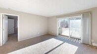 Located at 60 Sandy Ln in Warwick, Rhode Island, this one-bedroom, one-bathroom residence offers a practical and comfortable single-floor layout. The living room is bright and open, featuring soft carpeting, neutral-toned walls, and a sliding glass door that leads to a private balcony with views of surrounding natural foliage, allowing generous natural light to fill the space. Adjacent to the living area is a dedicated dining room, providing a clear separation between entertaining and relaxation areas. The kitchen is equipped with warm-toned wooden cabinetry extending to the ceiling for maximum storage, a stainless steel refrigerator, and a gas range, all set on easy-to-maintain wood-style flooring. The spacious bedroom offers carpeted floors, a large window with outdoor views, and baseboard heating for year-round comfort. Two closets provide ample storage, one of which is a walk-in style fitted with dual hanging rods and shelving. The full bathroom features a white vanity with a stone-style countertop, wood-look flooring, and a tub-shower combination. Throughout the residence, a consistent neutral color palette and baseboard heating system create a clean, cohesive, and comfortable living environment.