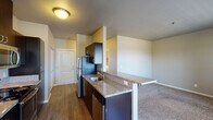 Located at 625 N Fifth St in Lebanon, Oregon, this single-floor unit offers a thoughtfully designed layout that balances comfort and functionality. The kitchen serves as a central highlight, featuring rich dark cabinetry, granite-style countertops, and a full suite of stainless steel appliances including a refrigerator, electric range, microwave, and dishwasher. A breakfast bar provides a convenient pass-through to the open living area, which transitions seamlessly between hardwood-style flooring in the kitchen and plush carpeting in the living and bedroom spaces. Natural light filters into the bedrooms through windows with blinds, and each room offers generous proportions with ample wall space. Closet storage is available in the bedrooms, supported by bifold doors. The bathroom is finished with matching granite-style countertops, a dark vanity cabinet, a large mirror, and a full tub-shower combination set over tile flooring. A dedicated in-unit laundry area accommodates a full-sized washer and dryer with overhead shelving for added storage. The unit's neutral color palette and consistent finishes throughout create a clean, cohesive ambiance well-suited for everyday living.