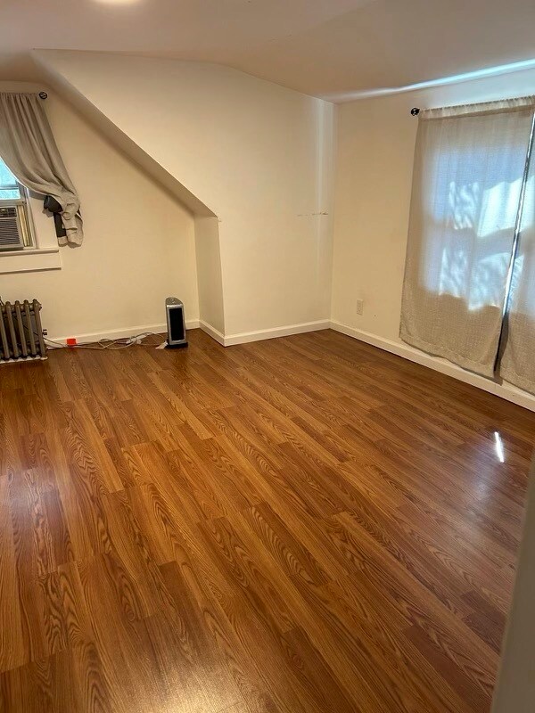 The large bedroom; more of the room. There are beautiful treetops outside the window curtain. - 565 Portland Ave