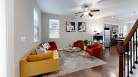 Located at 11945 Crooked Stick Pl in Pineville, NC, this two-story home offers 2 bedrooms and 4 bathrooms across two well-proportioned floors. The main level features an open-concept kitchen and living area with rich hardwood flooring throughout. The kitchen is a standout, boasting dark espresso cabinetry, granite countertops, stainless steel appliances including a refrigerator, range, and microwave, and a large peninsula with bar seating illuminated by pendant lighting. The living room is bright and welcoming, with multiple windows allowing natural light to fill the space, complemented by a ceiling fan overhead. Upstairs, the primary bedroom offers a generous layout with plush carpeting, a double-door closet, and a private en-suite bathroom featuring granite countertops and a tiled tub-shower combination. The second bedroom is equally comfortable, bathed in natural light from dual windows and finished with soft carpeting and a closet. The bathrooms throughout maintain a consistent, clean aesthetic with granite vanity tops and white cabinetry. Neutral warm-gray tones on the walls create a cohesive, modern ambiance across both floors, making this Pineville home a well-appointed and functional living space.