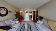 This single-floor residence in South Bend, Indiana offers a thoughtfully laid-out interior with distinct living zones connected by charming architectural details. The living room serves as the heart of the home, featuring sliding glass doors that invite natural light and offer a view of the outdoors, complemented by neutral-toned walls and carpet underfoot. A distinctive double-arched passageway connects the living room to the dining area and kitchen, adding a classic architectural touch that enhances the overall flow of the space. The dining area features warm hardwood flooring and a ceiling fan, providing a comfortable setting for everyday meals. The kitchen is equipped with dark wood cabinetry with brass hardware, a stainless steel sink, an electric range, a dishwasher, and light-colored countertops — offering practical functionality in a compact, efficient layout. Two bedrooms provide restful retreats, each with carpet flooring, neutral walls, and windows that bring in natural light; one bedroom includes a louvered closet door for added storage. The bathroom features a classic tub-shower combination adorned with warm yellow tile. Throughout the home, hardwood and carpet flooring create a comfortable and cohesive aesthetic.