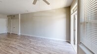 Located at 16310 Croft Dr. in Charlotte, NC, this one-bedroom, two-bathroom apartment offers a thoughtfully designed single-level layout that maximizes every inch of its compact footprint. The open-concept kitchen and living area serves as the heart of the unit, where wood-look luxury vinyl plank flooring flows throughout. The kitchen is equipped with stainless steel appliances, including a gas range, microwave, and French door refrigerator, complemented by warm taupe cabinetry, a subway tile backsplash, and granite countertops that extend to a peninsula with pendant lighting — ideal for casual dining or entertaining. The living area features a ceiling fan and natural light from a large window, with direct access to an outdoor balcony offering views of surrounding greenery. The bedroom is carpeted for comfort, fitted with a ceiling fan, and benefits from a dedicated window. It connects to a spacious walk-in closet lined with wire shelving. Two full bathrooms each feature granite-topped vanities and wood-look flooring, with the primary bath showcasing a dual-sink vanity. Neutral tones and clean finishes contribute to a bright, move-in-ready atmosphere throughout.