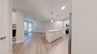 Located at 7350 Honore Avenue in Sarasota, Florida, this one-bedroom, one-bathroom residence offers a thoughtfully designed single-floor layout with modern finishes throughout. Light-toned luxury vinyl plank flooring runs continuously through every room, creating a cohesive and clean aesthetic.

The open-concept kitchen and living area serves as the heart of the home. The kitchen is outfitted with white shaker-style cabinetry, granite countertops, a full suite of stainless steel appliances — including a refrigerator, electric range, microwave, and dishwasher — and a central island with pendant lighting above. Recessed ceiling lights and a ceiling fan enhance the bright, airy atmosphere, while a balcony door provides natural light and outdoor access.

The bedroom offers a comfortable footprint with a ceiling fan, natural light from dual windows, and a double-door closet for generous storage. A connecting hallway leads to the full bathroom, which features granite countertops, white cabinetry, a single undermount sink, and a glass-enclosed walk-in shower. An in-unit laundry area adds everyday convenience. The overall palette — soft neutrals, white trim, and brushed nickel hardware — gives the space a clean, contemporary feel well-suited to Sarasota living.
