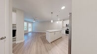 Located at 7350 Honore Avenue in Sarasota, Florida, this one-bedroom, one-bathroom residence offers a thoughtfully designed single-floor layout with modern finishes throughout. Light-toned luxury vinyl plank flooring runs continuously through every room, creating a cohesive and clean aesthetic.

The open-concept kitchen and living area serves as the heart of the home. The kitchen is outfitted with white shaker-style cabinetry, granite countertops, a full suite of stainless steel appliances — including a refrigerator, electric range, microwave, and dishwasher — and a central island with pendant lighting above. Recessed ceiling lights and a ceiling fan enhance the bright, airy atmosphere, while a balcony door provides natural light and outdoor access.

The bedroom offers a comfortable footprint with a ceiling fan, natural light from dual windows, and a double-door closet for generous storage. A connecting hallway leads to the full bathroom, which features granite countertops, white cabinetry, a single undermount sink, and a glass-enclosed walk-in shower. An in-unit laundry area adds everyday convenience. The overall palette — soft neutrals, white trim, and brushed nickel hardware — gives the space a clean, contemporary feel well-suited to Sarasota living.