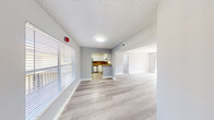 This 2-bedroom, 2-bathroom residence at 280 SW 56th Ter offers a thoughtfully designed single-floor layout with a clean, modern aesthetic throughout. Light-toned wood-style flooring extends across the living areas and bedrooms, complemented by soft gray walls, white baseboards, and textured ceilings that add subtle character to each room.

The open living area is bright and airy, with large windows dressed in horizontal blinds that invite natural light while providing privacy. The space flows seamlessly into the kitchen, which features white cabinetry, granite-toned countertops, a warm stone-style backsplash, and stainless steel appliances including a refrigerator and dishwasher.

The primary bedroom is generously sized, offering a closet and access to a hallway connecting the rest of the unit. The second bedroom is comfortable and well-lit, with a window overlooking the exterior. Both bedrooms continue the light flooring and neutral color palette found throughout the home.

The two bathrooms each include a tub-shower combination. The primary bath features marble-style wall surround panels with elegant veining, a granite-topped vanity, and wood-style flooring. The second bathroom offers classic tile surround and a matching granite vanity. A connecting hallway ties all rooms together, providing a functional and cohesive flow throughout the residence.