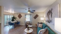 This single-story Houston, TX residence offers a thoughtfully arranged floor plan designed for comfortable everyday living. The living room serves as the heart of the home, featuring wood-look flooring, a ceiling fan with light fixture, and windows dressed with patterned curtains that invite natural light. The adjacent dining area connects seamlessly to the living space and includes sliding door access, enhancing the open, airy feel of the shared living zone.

The galley-style kitchen is efficiently designed with white cabinetry, light countertops, a subway tile backsplash, and black appliances including a refrigerator, electric range, and built-in microwave. Wood-look flooring continues throughout this space.

Both bedrooms are carpeted and equipped with ceiling fans. The primary bedroom features a closet and ample space, while the second bedroom also includes closet access and a ceiling fan. Each bathroom offers a white vanity with an undermount sink, large mirror, and overhead lighting. One bathroom features additional overhead cabinetry, while the other includes louvered cabinet accents, adding a distinctive design touch to both spaces.