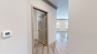 This contemporary 1010 square foot apartment offers a thoughtfully designed living space with two bedrooms and two bathrooms. The open floor plan creates a seamless flow between the living areas, enhancing the sense of spaciousness. Light-toned wood-look flooring runs throughout, complementing the neutral wall colors and adding warmth to the interior.

The primary bedroom, measuring 180 square feet, provides ample space for rest and relaxation. Both bedrooms feature large windows with horizontal blinds, allowing for adjustable natural light and privacy. Crown molding adds a touch of elegance to the rooms.

The bathrooms showcase modern fixtures, including sleek vanities with ample storage, large mirrors, and glass-enclosed showers. The kitchen boasts a functional layout with stainless steel appliances, granite countertops, and a stylish tile backsplash. White cabinetry enhances the bright, clean aesthetic.

Additional amenities include a dedicated laundry area with full-sized appliances, and spacious closets for storage. The apartment's design prioritizes functionality and contemporary style, creating an inviting home environment in McKinney, Texas.