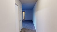This single-story home offers a thoughtfully arranged layout with four bedrooms, two bathrooms, a kitchen, two hallways, and a closet — all contained within a compact and efficient floor plan. The bedrooms are carpeted throughout, with the generously sized primary bedroom featuring a window that invites natural light and includes a built-in closet with louvered bifold doors. The additional bedrooms are similarly carpeted, with some featuring ceiling fans with integrated light fixtures and windows overlooking the outdoors. The kitchen is equipped with warm wood-toned cabinetry, ample upper and lower storage, a sink, dishwasher, electric range, and a full-size refrigerator, all set on hardwood-style flooring. A pass-through window with built-in cabinetry connects the kitchen area to an adjoining space, adding a functional and classic design detail. The two bathrooms are finished with hardwood-style flooring, warm wood vanity cabinetry, and white countertops. One bathroom features a shower-tub combination, while the other offers a walk-in shower with sliding glass doors. The hallways are carpeted and painted in soft blue tones, providing smooth transitions between rooms. Overall, the home presents a clean, functional, and neutral aesthetic suitable for a variety of living arrangements.