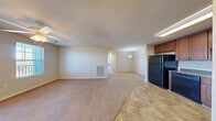 This single-story, three-bedroom unit at 700 Flint Drive in Newport News, Virginia offers a practical and comfortable layout designed for everyday living. The open-concept design connects the kitchen and living areas seamlessly, creating a spacious, communal feel. The kitchen is outfitted with warm-toned wood cabinetry, dark countertops, and black appliances including a refrigerator, range, and microwave. Stone-patterned tile flooring anchors the kitchen space, transitioning into soft carpet throughout the living and bedroom areas.

The generously sized living area benefits from a ceiling fan with lighting and an exterior door that allows natural light to filter in while providing access to outdoor views of the surrounding community. A pendant light fixture adds a subtle decorative touch near the dining area.

The bedrooms are carpeted and well-proportioned, with neutral walls and ample closet space, including double-door closets in at least one room. Windows fitted with blinds allow natural light while maintaining privacy. The bathroom features a full tub-shower combination with brushed nickel fixtures, tile flooring, and wood-toned cabinetry. Throughout the unit, a consistent neutral color palette creates a clean, move-in-ready environment.