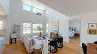Located at 616 NW Fifth St in Oklahoma City, this single-floor residence showcases a thoughtfully designed modern interior that balances openness with comfort. The living area immediately impresses with dramatically high, vaulted ceilings and an expansive wall of clerestory windows that flood the space with natural light, creating a bright and airy atmosphere. Warm hardwood flooring runs throughout the main living areas, anchoring the clean, white interior palette.

The open layout connects the living area to a dedicated dining space, both benefiting from generous ceiling height and an unobstructed flow. Large windows frame views of the surrounding neighborhood, enhancing the sense of spaciousness. The kitchen is well-appointed with white shaker cabinetry, quartz countertops, stainless steel appliances, a central island with pendant lighting overhead, and light tile flooring—providing both functionality and a polished aesthetic.

The bedrooms are comfortably scaled with hardwood floors, neutral walls, and ample natural light, with at least one offering outdoor views. The bathroom features a dual-sink vanity with white cabinetry, quartz countertops, hexagonal tile flooring, a walk-in tiled shower, and clean, contemporary fixtures throughout. Overall, the space conveys a cohesive modern design sensibility.