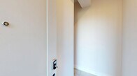 Located at 232 Gregory Ave in Passaic, NJ, this thoughtfully designed multi-level unit spans three floors, offering two bedrooms, three bathrooms, and a private garage. The layout is bright and contemporary throughout, with light-toned hardwood flooring and crisp white walls creating a clean, modern aesthetic.

The main living level hosts an open-plan kitchen and living room bathed in natural light from multiple windows. The kitchen is a standout feature, boasting light wood flat-front cabinetry, a striking quartz-topped island, white subway tile backsplash, stainless steel appliances including a gas range, and a matte black sink fixture. Recessed lighting adds a polished finishing touch.

The bedrooms are serene and well-proportioned, with light hardwood floors and clean white walls. The spacious primary bedroom includes access to a well-organized walk-in closet with built-in shelving. The second bedroom is equally bright and versatile.

All three bathrooms are elegantly finished with large-format tile, floating vanities, matte black hardware, and oval LED-backlit mirrors. One bathroom features a walk-in glass-enclosed shower with integrated bench and niche, while another includes a tub-shower combination. A private garage on the ground level completes this refined and functional home.