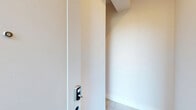 Located at 232 Gregory Ave in Passaic, NJ, this thoughtfully designed multi-level unit spans three floors, offering two bedrooms, three bathrooms, and a private garage. The layout is bright and contemporary throughout, with light-toned hardwood flooring and crisp white walls creating a clean, modern aesthetic.

The main living level hosts an open-plan kitchen and living room bathed in natural light from multiple windows. The kitchen is a standout feature, boasting light wood flat-front cabinetry, a striking quartz-topped island, white subway tile backsplash, stainless steel appliances including a gas range, and a matte black sink fixture. Recessed lighting adds a polished finishing touch.

The bedrooms are serene and well-proportioned, with light hardwood floors and clean white walls. The spacious primary bedroom includes access to a well-organized walk-in closet with built-in shelving. The second bedroom is equally bright and versatile.

All three bathrooms are elegantly finished with large-format tile, floating vanities, matte black hardware, and oval LED-backlit mirrors. One bathroom features a walk-in glass-enclosed shower with integrated bench and niche, while another includes a tub-shower combination. A private garage on the ground level completes this refined and functional home.