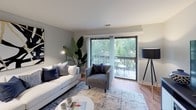 Located at 712 Andermann Ln in Darien, Illinois, this single-floor residence offers a thoughtfully designed layout with a warm, contemporary aesthetic throughout. The living room serves as the heart of the home, featuring hardwood-style flooring, soft neutral-toned walls, and large sliding glass doors that flood the space with natural light and open onto a private balcony with pleasant outdoor views. The dining area sits adjacent to the entry, appointed with a ceiling fan and wood-toned flooring that ties seamlessly into the main living spaces. The kitchen is functionally equipped with warm wood cabinetry, light countertops, stainless steel appliances including a range, microwave, and dishwasher, and classic tile flooring. Two well-proportioned bedrooms provide comfortable retreats; the primary bedroom benefits from a generous window with garden views and ample closet space, while the secondary bedroom also features hardwood-style flooring and a closet. Two bathrooms serve the residence — one with a tub/shower combination and another with a glass-enclosed shower stall — both finished in clean, neutral tones. Throughout the home, a cohesive cool-gray palette and consistent flooring create a unified, inviting atmosphere ideal for everyday living.