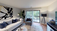 Located at 712 Andermann Ln in Darien, Illinois, this single-floor residence offers a thoughtfully designed layout with a warm, contemporary aesthetic throughout. The living room serves as the heart of the home, featuring hardwood-style flooring, soft neutral-toned walls, and large sliding glass doors that flood the space with natural light and open onto a private balcony with pleasant outdoor views. The dining area sits adjacent to the entry, appointed with a ceiling fan and wood-toned flooring that ties seamlessly into the main living spaces. The kitchen is functionally equipped with warm wood cabinetry, light countertops, stainless steel appliances including a range, microwave, and dishwasher, and classic tile flooring. Two well-proportioned bedrooms provide comfortable retreats; the primary bedroom benefits from a generous window with garden views and ample closet space, while the secondary bedroom also features hardwood-style flooring and a closet. Two bathrooms serve the residence — one with a tub/shower combination and another with a glass-enclosed shower stall — both finished in clean, neutral tones. Throughout the home, a cohesive cool-gray palette and consistent flooring create a unified, inviting atmosphere ideal for everyday living.