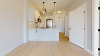 Located in Langley, BC, this well-designed one-bedroom, one-bathroom unit offers a thoughtfully organized layout across a single floor. The open-concept kitchen and living area serves as the heart of the space, featuring crisp white cabinetry with black hardware, a subway tile backsplash, a peninsula with an integrated sink, and a full suite of stainless steel appliances including a range, microwave, dishwasher, and refrigerator. Pendant lighting and track lighting illuminate the kitchen, while light-toned hardwood-style flooring and white walls create a clean, airy atmosphere throughout the main living area. A sliding door provides access to an outdoor balcony, allowing natural light to flow into the space. The bedroom is a comfortable, carpeted retreat with a large window overlooking the surrounding neighbourhood, offering pleasant outdoor views and abundant natural light. The room includes access to a dedicated closet, providing practical storage. The bathroom is finished with a modern wood-toned vanity, white quartz countertop, a large mirror, and a full tub-shower combination. The overall ambiance of the unit is fresh and contemporary, with a neutral palette and modern detailing that gives the space a clean, move-in-ready feel.