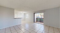 Located at 8118 Spring Hill Dr in Spring Hill, FL, this single-story 2-bedroom, 1-bathroom home offers a practical and well-organized layout. The combined living and dining area is finished with light ceramic tile flooring and features a textured ceiling throughout. A sliding glass door opens to an outdoor patio, filling the space with natural light and providing easy access to the outdoors. A peninsula counter separates the dining area from the kitchen, which is equipped with dark granite countertops, white cabinetry with modern hardware, a full appliance suite including an electric range, built-in microwave, and refrigerator.

Both bedrooms feature light wood-style laminate flooring, neutral gray walls, and textured ceilings. The primary bedroom includes a set of double closet doors offering generous storage, while the second bedroom is also well-sized with natural light from a window. Each room provides a bright and comfortable atmosphere. The full bathroom is accessible from the hallway and includes a tub-shower combination and tile flooring. A connecting hallway links all rooms efficiently. The home's clean, neutral palette and updated finishes make it a functional and inviting space throughout.