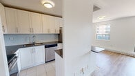 Located at 7411 Yonge Street in Markham, Ontario, this well-laid-out two-bedroom, one-bathroom unit offers a clean, modern aesthetic throughout. Light-toned hardwood flooring runs across the main living areas and bedrooms, lending warmth and continuity to the space.

The open living room is bright and airy, featuring crisp white walls and a large sliding glass door that floods the room with natural light and frames views of the surrounding neighbourhood. The adjacent dining area connects seamlessly to the kitchen, which is outfitted with white shaker-style cabinetry, dark countertops, a subway tile backsplash, and stainless steel appliances including a refrigerator, stove, and dishwasher. Tile flooring in the kitchen provides a practical transition from the rest of the unit.

Both bedrooms are comfortably sized, each featuring large windows that bring in ample daylight and offer neighbourhood views, along with baseboard heating for year-round comfort. The primary bedroom provides a generous footprint suitable for a full bedroom suite.

The bathroom is finished with floor-to-ceiling neutral tile, a full soaker tub with an overhead shower, and chrome fixtures, offering a clean and functional design. Overall, the unit presents a bright, move-in ready living space in a convenient Markham location.
