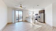 Located at 2818 Cullman Ave in Charlotte's 28206 neighborhood, this single-floor unit showcases a clean, contemporary design with an open-concept layout that seamlessly connects the living and kitchen areas. Light-toned hardwood-style flooring runs throughout the main living spaces, enhancing the bright, airy atmosphere created by abundant natural light. A ceiling fan with a brass accent fixture anchors the living area, which flows directly to a private balcony through a sliding glass door, offering outdoor access and views of the surrounding neighborhood.

The kitchen is well-appointed with stainless steel appliances, including a refrigerator, electric range, and over-the-range microwave. A granite-topped island with pendant lighting serves as a central workspace and casual dining area, complemented by white upper cabinetry, dark lower cabinetry, and a subway tile backsplash.

The bedrooms feature plush carpeting, ceiling fans, and well-sized windows fitted with blinds that allow for natural light and privacy. Closet storage is included in the bedrooms.

The bathrooms are finished with wood-toned vanity cabinetry, granite countertops, and light wood-look tile flooring. One bathroom includes a full soaking tub with a tiled surround, while another features a vanity with separate water closet, offering a functional and refined design throughout.