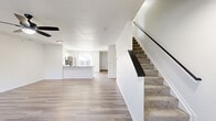 Located at 4455 Winchester Pike in Groveport, Ohio, this two-story home offers a clean, modern aesthetic with a functional layout spread across two floors. The main level features an open-concept living area with light-toned luxury vinyl plank flooring, a ceiling fan, and natural light from a window near the front entrance. The kitchen includes a breakfast bar peninsula, granite-look countertops, white cabinetry, and stainless steel appliances, flowing seamlessly into the living space. A carpeted staircase with a sleek dark handrail connects the two floors. Upstairs, the generously sized primary bedroom features plush carpet, a ceiling fan, and a dedicated closet with built-in wire shelving for ample storage. Two additional bedrooms are equally well-lit, each with carpet flooring, ceiling fans, and access to the hallway. Three full bathrooms are finished with white cabinetry, granite-style countertops, black hardware accents, and tub-shower combinations. Closets are found throughout the home, including a walk-in with wire rack shelving. A utility room and hallway complete the practical floor plan. The home's consistent white walls, modern fixtures, and neutral palette create a bright and move-in ready environment.