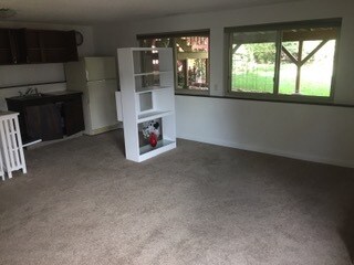 living room with view to back yard - Gilcrest Apartments - Utilities Included