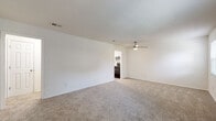 Located at 10611 SR-204 W in Savannah, Georgia, this single-story unit offers a straightforward, functional layout spread across several well-defined spaces. The floor plan, visible in the 3D model, reveals an efficiently organized arrangement connecting the main living area, kitchen, bedrooms, and bathroom.

The living area is generously proportioned, featuring neutral-toned wall-to-wall carpeting, crisp white walls, a textured ceiling, and a ceiling fan. Two windows fitted with blinds allow natural light to filter in, creating a bright and open atmosphere. An entry area opens directly into this space, providing a welcoming transition into the unit.

The kitchen has been thoughtfully updated, showcasing white shaker-style cabinetry, granite-look countertops, a subway tile backsplash, and light wood-look flooring. Black appliances, including a refrigerator, dishwasher, and range, provide a strong contrast against the bright cabinetry.

The bedrooms continue the carpeted flooring and white wall palette, each equipped with ceiling fans and natural light from windows with blinds. One bedroom features a sliding-door closet with built-in shelving, offering practical storage. The bathroom includes a tub and shower combination with tiled surround, a granite-topped vanity with white cabinetry, and wood-look flooring, completing the unit's cohesive, clean aesthetic.
