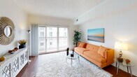 This single-floor residence offers a thoughtfully designed layout that balances comfort and functionality. The bright living room serves as the heart of the space, featuring rich hardwood flooring, a large sliding glass door that opens to a private balcony, and abundant natural light that fills the room throughout the day. A plush area rug and glass coffee table complement the welcoming atmosphere.

The kitchen is well-equipped with warm maple cabinetry, granite countertops, and stainless steel appliances including a refrigerator, range, and microwave. A peninsula with bar seating provides a casual dining option and connects the kitchen seamlessly to the living and dining areas, enhancing the open-concept flow of the space.

The bedroom is a serene retreat with soft carpeting, a walk-in closet offering generous storage, and a sliding door with vertical blinds that allows for natural light and outdoor access. A full bathroom features tile flooring, a granite vanity with ample counter space, and a full-sized tub and shower combination.

Throughout the residence, neutral tones, clean lines, and consistent finishes create a cohesive and inviting aesthetic, making this a comfortable and practical living space.