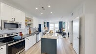 Located at 20 Water Grant St in Yonkers, NY, this thoughtfully designed one-bedroom, one-bathroom residence offers a well-appointed layout filled with natural light and curated modern details. Light wood flooring flows throughout, complementing the bright, airy palette of each room.

The living room is a visual standout, featuring bold herringbone-patterned wallpaper, recessed lighting, and large French doors that open onto a private balcony with sweeping Hudson River views. The space accommodates comfortable seating and stylish storage with ease.

The kitchen is outfitted with white shaker cabinetry, a classic subway tile backsplash, dark countertops, and a full suite of stainless steel appliances. A charming newsprint-style accent wall adds personality to the space.

The bedroom is a serene retreat, highlighted by a textured accent wall, large windows framing expansive water views, and ample room for a king-sized bed and additional seating. A dedicated closet provides convenient storage.

The bathroom features a full soaking tub and shower combo clad in white subway tile, a dark wood vanity with a crisp white countertop, and clean, minimalist finishes throughout. The private balcony completes this residence, offering elevated views of the surrounding waterfront neighborhood.