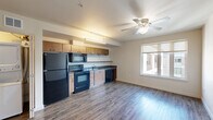 Located at 7227 N Philadelphia Ave in Portland, Oregon, this one-bedroom, one-bathroom unit offers a thoughtfully organized single-floor layout. The entrance leads past two closets, providing generous storage right from the start. The heart of the unit is an open-concept living, dining, and kitchen area that maximizes the available space. The kitchen is equipped with black appliances — including a full-size refrigerator, electric range, built-in microwave, and dishwasher — complemented by warm wood-toned cabinetry and a functional countertop workspace. A ceiling fan and a window allowing natural light make the living area feel bright and comfortable. Wood-look plank flooring extends throughout the main living space, adding warmth and visual continuity. The bedroom features wall-to-wall carpet for added comfort and is a well-proportioned private retreat. The bathroom offers a clean, modern finish with a wood-tone vanity, gray countertop, a large mirror, a full tub/shower combination with accessibility grab bars, and concrete-style flooring. A dedicated laundry area adds everyday convenience. The overall design is clean and functional, suited to efficient urban living in North Portland.