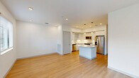 Located in Royal Palm Beach, FL, this two-story home offers a well-designed layout across two floors, with the main living areas on the ground level and the bedrooms above. The open-concept main floor seamlessly connects the living room and kitchen, both finished with warm light wood flooring and crisp white walls that maximize the natural light flowing in through multiple windows. The kitchen is outfitted with white shaker-style cabinetry, a tile backsplash, stainless steel appliances including a refrigerator, dishwasher, and microwave, and a central island with pendant lighting overhead — ideal for both cooking and casual dining. Sliding glass doors in the living area provide direct outdoor access and views of the surrounding landscape. The upper floor houses three bedrooms, each featuring light wood flooring, ceiling fans, and natural light from slatted windows. The spacious primary bedroom is complemented by a well-appointed en-suite bathroom with a tiled walk-in shower, lighted vanity mirror, and sage-toned cabinetry. Four closets throughout the home, including a walk-in with wire shelving, provide ample storage. A dedicated laundry space, hallway, and an attached garage with automatic opener round out this thoughtfully functional home.