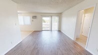 Located at 8825 Woodman Ave in Arleta, CA, this single-floor, 2-bedroom, 2-bathroom unit offers a well-organized and functional layout. The open living and dining area is bright and welcoming, featuring wood-style plank flooring, neutral white walls, and a textured ceiling. A wall-mounted air conditioning unit keeps the space comfortable, while a sliding glass door opens directly onto a private balcony, allowing natural light to pour in and offering outdoor views of the surrounding neighborhood.

The galley-style kitchen is efficiently designed with ample white cabinetry, granite-toned countertops, a double-basin sink, and a tile floor — providing generous prep and storage space. Both bedrooms are comfortably sized, with the primary bedroom offering notable square footage. Each bedroom features wood-style flooring, ceiling fans, vertical blinds for light control, and mirrored sliding closet doors that enhance the sense of space. In total, four closets are distributed throughout the unit, ensuring abundant storage. The two bathrooms are clean and functional, each featuring tile flooring, windowed natural light, granite-accented vanities, and chrome fixtures. A connecting hallway ties all rooms together in a cohesive, easy-to-navigate floor plan.