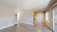Located at 816-822 W A St in Hayward, California, this single-floor 2-bedroom, 2-bathroom unit offers a practical and comfortable layout. The open living area is finished with durable wood-look flooring, neutral gray walls, and white baseboards, creating a clean and cohesive aesthetic throughout. A wall-mounted heater unit in the living area adds functional convenience. The kitchen features warm honey-toned wood cabinetry, granite-style countertops, and a ceiling fan overhead, with a large window that brings in natural light and views of the surrounding greenery. Both bedrooms are carpeted for added comfort and are equipped with windows that allow natural light to fill each room. The primary bedroom includes a closet with a hanging rod, providing practical storage. A hallway connects the main living areas to the bedrooms and two bathrooms. The first bathroom includes a white vanity, a tub-shower combination with tiled surround, and wood-look flooring. The second bathroom features a glass-enclosed shower, a white vanity, and matching flooring. Together, these spaces offer a clean, move-in-ready home in a well-established Hayward neighborhood.