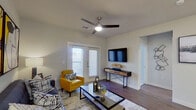This single-floor residence offers a thoughtfully designed layout that balances style and functionality throughout. The living area serves as the heart of the space, featuring rich hardwood-style flooring, a ceiling fan with integrated lighting, and a glass-panel door that invites abundant natural light. Contemporary furnishings, bold abstract wall art, and a glass-top coffee table contribute to a modern, curated ambiance.

The kitchen is well-equipped with stainless steel appliances, including a range, microwave, and dishwasher, complemented by crisp white cabinetry and light granite countertops. The clean lines and efficient layout make it both practical and visually appealing.

The bedroom is a serene retreat, highlighted by large windows that flood the room with natural light and offer outward views. Plush carpeting and ample space create a comfortable, restful environment.

The bathroom features a full tub-shower combination with clean white tile surround, granite countertops, white cabinetry, and hardwood-style flooring, maintaining the consistent, polished aesthetic found throughout the unit.

A dedicated laundry area with an in-unit washer and built-in shelving above adds everyday convenience. Together, each space reflects a cohesive modern design with quality finishes throughout.