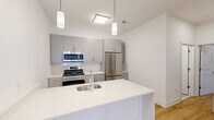 Located on Crosskeys Lane in Ewing, NJ, this well-appointed 2-bedroom, 2-bathroom residence offers a thoughtfully designed single-level floor plan with modern finishes throughout. The open-concept living and dining area is bright and airy, featuring light hardwood-style flooring and large windows fitted with roller shades that invite natural light while framing pleasant outdoor views of greenery. A private balcony extends the living space outdoors.

The contemporary kitchen is a standout feature, showcasing a sleek quartz waterfall island with an undermount sink, gray flat-front cabinetry, a white subway tile backsplash, and a full suite of stainless steel appliances including a gas range, over-the-range microwave, and French door refrigerator. Pendant lighting adds a stylish finishing touch above the island.

The spacious primary bedroom includes generous closet space with a dedicated walk-in area featuring built-in rods. Two full bathrooms are finished with gray vanity cabinetry, quartz countertops, light tile flooring, and wall-mounted storage cabinets — one with a soaking tub and the other with a walk-in shower. An in-unit laundry area and three closets provide excellent storage throughout this clean, modern home.