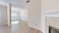 Located in Jacksonville, FL (32256), this thoughtfully designed home offers a welcoming layout with a blend of light hardwood-style flooring and plush carpeting throughout. The open living area is anchored by a tile-surround fireplace and features crown molding, a ceiling fan, and an elegant arched doorway that connects to additional living spaces. Adjacent to the living room, a decorative column separates the formal dining area, which is appointed with wainscoting panels and a classic chandelier that adds a refined touch.

The kitchen is well-equipped with white cabinetry, light countertops, stainless steel appliances including a range and over-the-range microwave, and a built-in wine rack. A walk-in pantry provides generous storage just steps away.

The spacious bedrooms feature plush carpeting, tray ceilings, ceiling fans, and multiple windows that invite abundant natural light and views of surrounding greenery. The primary bathroom offers both a soaking tub and a separate walk-in shower, finished with wood-look flooring for a clean, modern aesthetic. A secondary bathroom mirrors this style with a tiled tub-shower combination.

A carpeted staircase with a clean white handrail completes the interior, connecting the levels with a streamlined, functional design throughout.