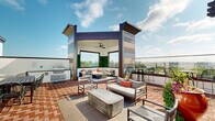 Located at 9015 Eager Rd in Richmond Heights, MO, this rooftop terrace offers an expansive open-air retreat with a well-designed layout suited for both relaxation and entertainment. The herringbone-patterned brick flooring spans the entire level, lending a classic yet contemporary aesthetic throughout the space.

A central covered pavilion serves as the focal point, featuring a ceiling fan, built-in bench seating with cushions and accent pillows, and a living wall of lush greenery. Adjacent to the pavilion, an outdoor kitchen station is equipped with a stainless steel gas grill, providing a dedicated area for outdoor cooking and gatherings.

Multiple seating zones are distributed across the terrace, including a casual lounge area with modern upholstered chairs and a concrete coffee table, a dining table with wire-frame chairs, and a pergola-shaded section outfitted with a mounted flat-screen television and additional dining seating — ideal for group events or screenings.

Glass perimeter railings line the edges of the terrace, preserving unobstructed panoramic views of the St. Louis skyline, surrounding treetops, and the broader Richmond Heights neighborhood. High-top bistro tables and bar-height chairs are positioned along the railing to take full advantage of these sweeping vistas. Potted greenery adds natural accents throughout, enhancing the outdoor ambiance of this versatile rooftop space.