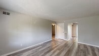 Located at 7852 Marten Ct W in Lawrence, Indiana, this single-story home offers four bedrooms, one bathroom, and a thoughtfully arranged floor plan connected by a central hallway. Consistent luxury vinyl plank flooring runs throughout the home, lending a clean, modern look to every room.

The home features two kitchen areas, each equipped with warm honey-toned wood cabinetry, dark granite-style countertops, and black appliances including a refrigerator, range, dishwasher, and microwave — providing excellent functionality. A stainless steel sink adds a contemporary touch to the workspace.

The spacious primary bedroom benefits from a large window that invites natural light and offers views of surrounding greenery. Additional bedrooms are well-proportioned with neutral gray walls and ample natural light. The single full bathroom includes a tub-shower combination with a clean white surround and chrome fixtures.

A dedicated utility room features hookups for laundry appliances along with built-in shelving, adding practical storage. Two closets throughout the home provide further organization. Textured ceilings and crisp white trim are consistent throughout, completing the home's clean, move-in-ready aesthetic.