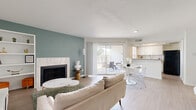 Located at 12903 Brant Rock Dr in Houston, TX, this single-floor residence offers a well-organized layout that includes a living room, kitchen, bedroom, bathroom, and two closets. The open-concept living and dining area is a standout feature, highlighted by light wood-style flooring, a tile-surround fireplace set against a teal accent wall, and built-in shelving. A sliding glass door floods the space with natural light and provides direct access to a private outdoor patio. The kitchen is efficiently designed with white cabinetry, granite countertops, a hexagonal tile backsplash, stainless steel sink, and a natural light-filled window above. The bedroom is a calm retreat featuring clean white walls with a warm neutral accent, a ceiling fan, and direct access to a bright bathroom. Two closets, including a spacious walk-in with built-in shelving and hanging rods, offer generous storage. Throughout the home, a cohesive palette of whites, neutrals, and soft accent colors creates a bright, modern ambiance that balances style and practicality — an ideal home for those seeking comfortable, efficient living in West Houston.