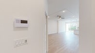This well-designed two-story home offers a thoughtful layout across two floors, combining functionality with a bright, modern aesthetic. Light hardwood flooring runs throughout, complemented by crisp white walls that create a clean, airy atmosphere.

The main floor opens with an entrance that flows into an open-concept kitchen and living area. The kitchen is a standout, featuring white shaker cabinetry, quartz countertops, a central island with pendant lighting, stainless steel appliances, and a neutral tile backsplash. Large sliding glass doors flood the space with natural light and provide views of the outdoors. The living area is generously sized with recessed lighting, a ceiling fan, and a seamless connection to the kitchen.

Upstairs, three bedrooms provide comfortable accommodations. The spacious primary bedroom includes a tray ceiling, ceiling fan, and access to a closet. The secondary bedrooms are well-proportioned with natural light from windows with blinds. The hallway connects all upper-level rooms efficiently.

Two full bathrooms serve the home. One features a soaking tub with a shower combo and brushed gold fixtures, while the other showcases a bold blue tile walk-in shower enclosure with a glass door and natural light from a window. Both bathrooms include white vanities with quartz countertops and tile flooring.