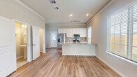 Located in Montgomery, TX, this two-story home offers a well-designed open-concept layout that seamlessly connects the main living areas. The foyer welcomes you with light wood-look flooring, crown molding, and a classic staircase featuring white balusters and a warm wood handrail, setting an inviting tone throughout the first floor.

The spacious living room is bathed in natural light from multiple large windows with plantation-style blinds, and features a ceiling fan and crown molding. It flows directly into the kitchen, which is a standout feature of the home. White shaker cabinetry, a subway tile backsplash, granite countertops, and stainless steel appliances — including a refrigerator, range, and microwave — combine for a clean, modern aesthetic. A generous kitchen island with a granite surface and undermount sink provides additional workspace and casual seating.

Bathrooms are finished with neutral tile flooring, granite vanity tops, and brushed nickel fixtures. One bathroom includes a tiled tub-shower combination. Bedrooms are carpeted in a neutral tone and include natural light from exterior-facing windows. Throughout the home, a consistent palette of warm neutrals, crown molding, and quality finishes creates a cohesive and comfortable living environment across both floors.