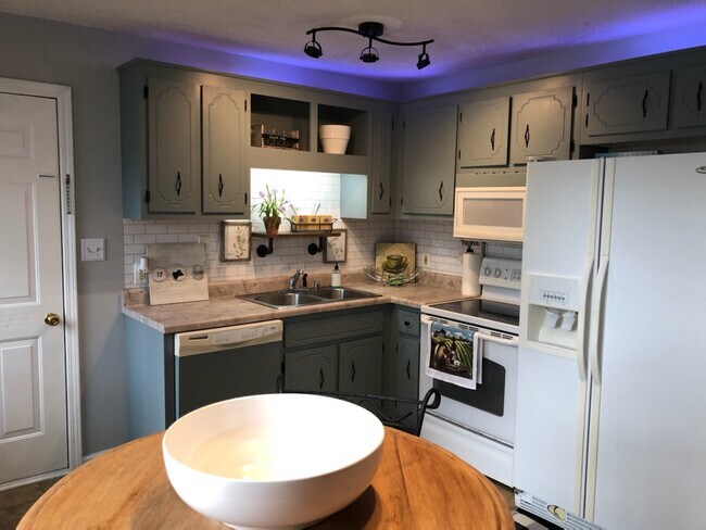 Comodidades completas en la cocina que incluyen platos, cubiertos y utensilios de cocina. - 217 Waterford Dr