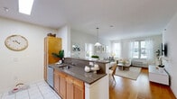 Located at Landmark Place in Long Branch, NJ, this well-designed two-bedroom, two-bathroom residence offers a comfortable and functional single-floor layout. The open-concept kitchen and dining area serves as the heart of the home, featuring warm honey-toned cabinetry, stainless steel appliances including a refrigerator and microwave, dark granite countertops, and a peninsula that doubles as a breakfast bar. Tile flooring in the kitchen transitions seamlessly to hardwood in the adjacent dining and living areas. The living room is bright and inviting, with multiple windows allowing abundant natural light and views of the outdoors. The primary bedroom is generously proportioned, boasting plush carpeting, a soft neutral palette with a grey accent wall, and natural light from a large window. The second bedroom also features carpet flooring, a built-in closet, and a coordinating grey accent wall. Both bathrooms are finished with tile flooring, warm wood vanities, granite countertops, and tub-shower combinations. Three closets throughout the residence provide ample storage. The overall ambiance is clean, bright, and cohesive, with a neutral color scheme that creates a welcoming atmosphere throughout.