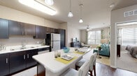 Located at 100 Myrtle St in Longwood, Florida, this single-floor residence offers a thoughtfully designed open-concept layout that seamlessly connects the kitchen, dining, and living areas. The kitchen is a standout feature, showcasing rich dark-espresso cabinetry, white quartz countertops, stainless steel appliances including a refrigerator, range, microwave, and dishwasher, and a central island with bar seating. Warm hardwood-style flooring runs through the kitchen and dining area, while neutral carpet flows into the living room. The living area is bright and welcoming, benefiting from large windows that allow generous natural light and a ceiling fan overhead. Two well-proportioned bedrooms each feature plush carpet, large windows, and ceiling fans, creating comfortable and serene retreats. The unit includes two full bathrooms: one with a tub-shower combination and an extended vanity with dark cabinetry, and a second featuring a glass-enclosed shower with tile surround and a matching vanity. Light tile flooring is consistent across both bathrooms. Throughout the unit, neutral tones, clean lines, and contemporary fixtures contribute to a cohesive, modern aesthetic that is both functional and inviting.